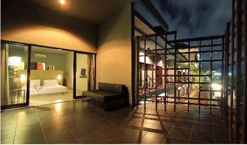 a large room with a bed and a balcony at The Grey Boutique Inn in Legian