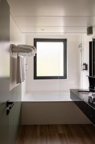 a white kitchen with a window and a sink at Maison du Lac Boutique Hôtel in Nyon