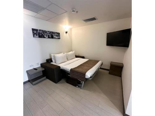 a small room with a bed and a flat screen tv at Best Western Plus Urban Larco Hotel in Lima