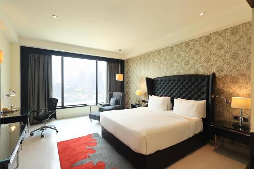 a hotel room with a bed and a desk and chair at Radisson Blu Hotel New Delhi Paschim Vihar in New Delhi