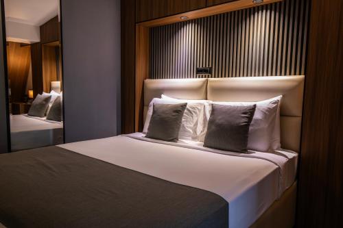 a bedroom with a large bed with white sheets and pillows at View Inn Boutique Hotel in Skopje