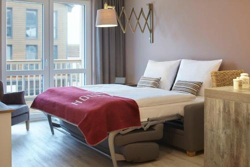 una cama en una habitación con una ventana grande en Comfort One Bedroom, en Heiligenhafen