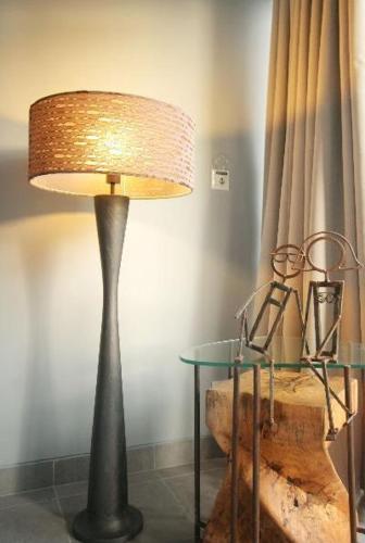 a lamp in a room with a table and a lamp at The Grey Boutique Inn in Legian