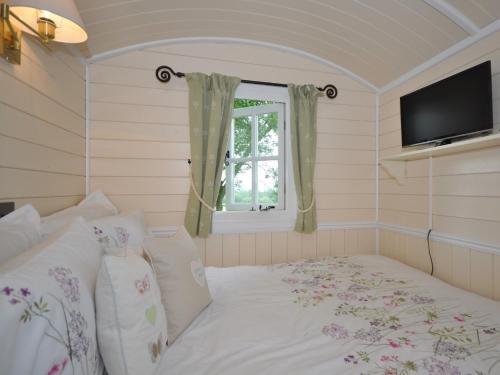 a bedroom with a bed with a window and a television at 1 Bed in Longtown 44235 in Longtown
