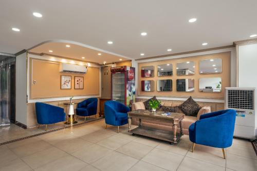 a living room with a couch and blue chairs at SAZI Erato Hotel - Free Airport & Breakfast in Ho Chi Minh City