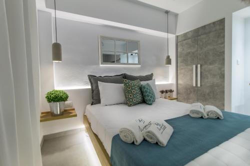 a bedroom with a large white bed with towels on it at Margaret of Naxos in Agios Prokopios