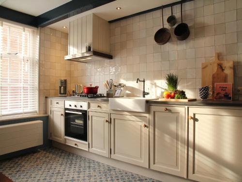 a kitchen with white cabinets and a sink at Holiday Home in Hindeloopen by Lake in Hindeloopen