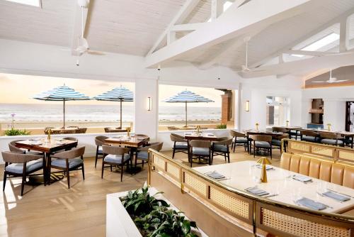 a restaurant with tables and chairs and the beach at La Jolla Beach & Tennis Club in San Diego