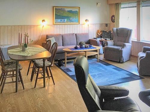 a living room with a couch and a table and chairs at 8 person holiday home in Kaldfarnes in Kaldfarnes