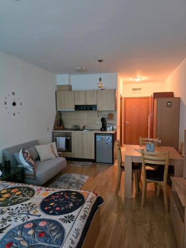 a living room with a couch and a table and a kitchen at Aspen Valley in Razlog