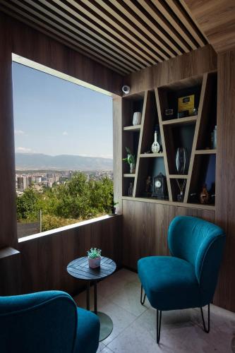 a room with a large window and two chairs and a table at View Inn Boutique Hotel in Skopje