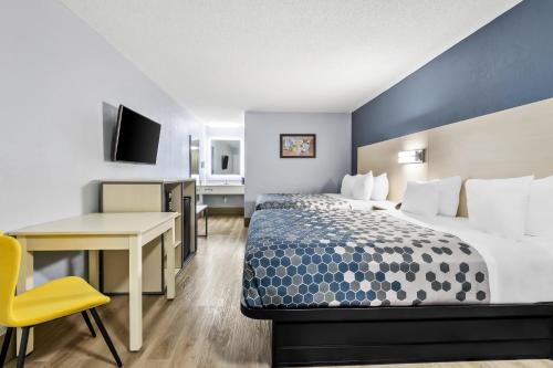 a hotel room with a bed and a desk and a computer at Econo Lodge Inn & Suites Cayce I-26 Airport in Cayce