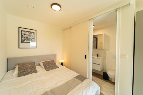 a bedroom with a bed and a bathroom at Fourstay Luxury City Apartments Diegem - Brussels in Diegem