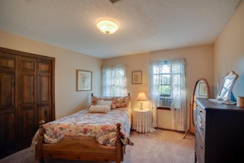 Un dormitorio con una cama y una cómoda y una ventana. en Dayton Home with Pool and Deck on 37 Private Acres!, en Dayton