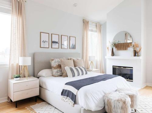 a white bedroom with a bed and a fireplace at Hotel Olive Aero Suites Near Delhi IGI Airport in New Delhi
