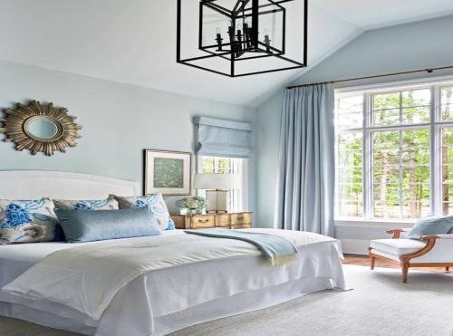 a bedroom with a white bed and a chandelier at Hotel Olive Aero Suites Near Delhi IGI Airport in New Delhi