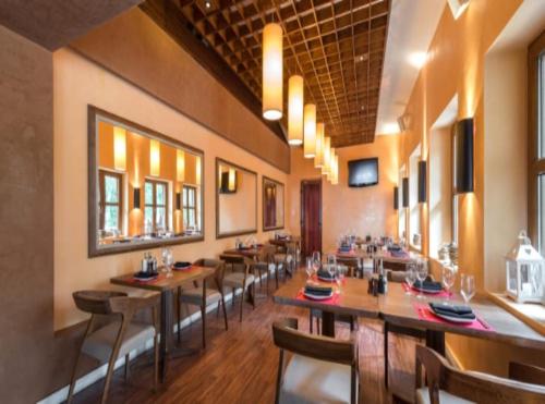 a dining room with wooden tables and chairs at Hotel Olive Aero Suites Near Delhi IGI Airport in New Delhi