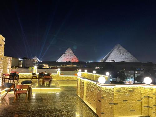 a view of the pyramids from a balcony at night at Pyramids Khufu Solar Boat Hotel in Cairo