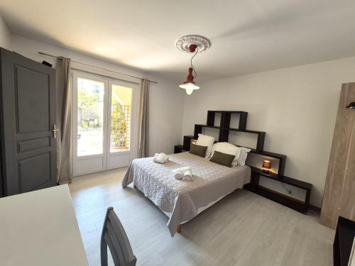 Un dormitorio con una cama y una ventana grande. en La parenthèse, en Lucciana