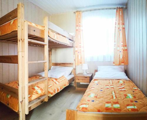 a bedroom with two bunk beds and a window at OW NaFali in Jarosławiec
