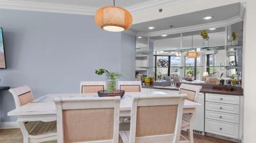 a dining room with a white table and chairs at Enjoy a 3-bedroom Bayfront Condo with Lazy River Indoor Pool Jacuzzis and Community Boat Dock for Personal or Rented Boats Plus Redeem in Free Activity Deals Daily in Orange Beach
