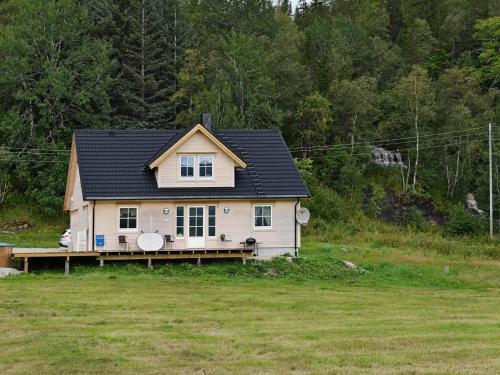a small house with a black roof in a field at 7 person holiday home in Foldereid-By Traum in Årfor