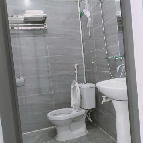 a bathroom with a toilet and a sink at Hoa Sơn Tra Hotel in Mù Cang Chải