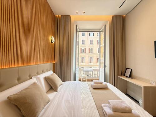 a bedroom with a large white bed with a window at Luxe roma in Rome