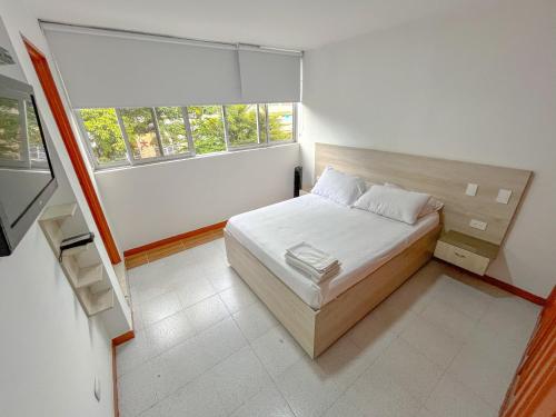 a small bedroom with a bed and a window at NEÓN TOLIMA - Hotel en Zona Centro de Ibagué - Recepción y Atención Digital 24H in Ibagué