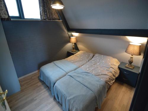 a bed in a bedroom with two lamps on tables at Holiday Home in Stramproy near Forest in Stramproy