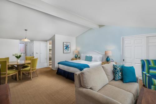 a bedroom with a bed and a couch and a table at La Jolla Beach & Tennis Club in San Diego