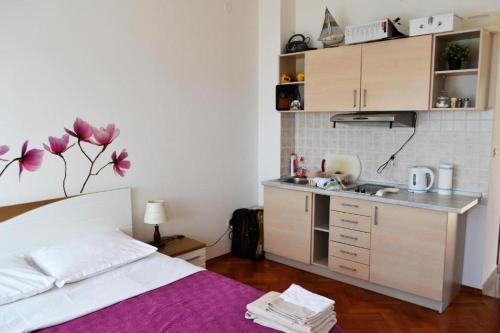 a bedroom with a bed and a small kitchen at Apartments with sea view in Kožino