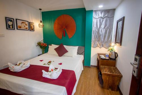 a bedroom with a bed with a green wall at NT Elysian hotel in Hanoi