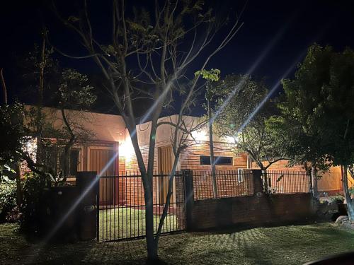 a house at night with lights on a fence at House for World Rally-Paraguay in Hohenau