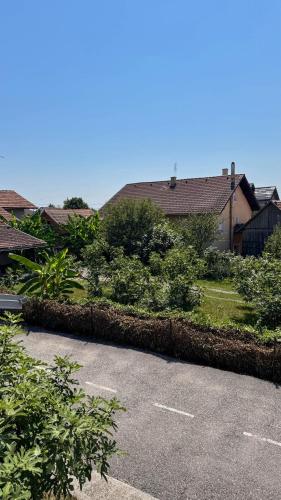 a parking lot with some bushes and a house at Apartmani Moslavina, free big parking, workspace, crib, satin cotton sheets in Kutina