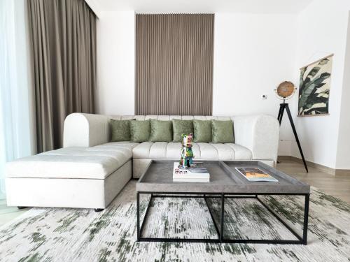 a living room with a white couch and a coffee table at Luxury Retreat 1BDR Apartment in Yas Island Premium Location with Pool and Gym in Yas Island