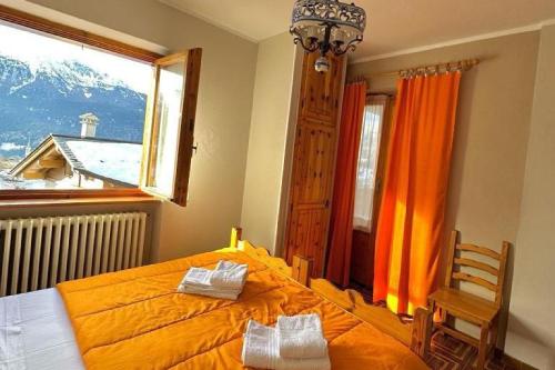 a bedroom with an orange bed and a window at Albergo Ristorante Ginepro in Bormio