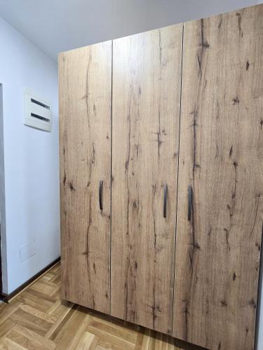 a large wooden cabinet in a room with wooden floors at Stan na dan Centar Čačak in Čačak