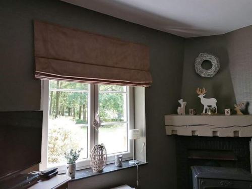 a kitchen with a window with a deer figurines on a mantle at Sunny Garden Cottage, Alle in Frahan