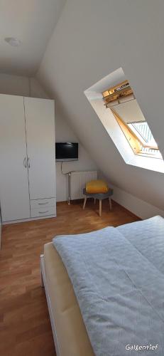 a attic bedroom with a bed and a skylight at Uns Lüttje in Norden