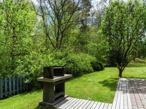 a stone bench in a garden with trees and grass at Sunny Garden Cottage, Alle in Frahan