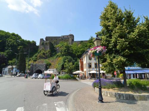 a person riding a bike down a street with a castle at Sunny Garden Cottage, Alle in Frahan