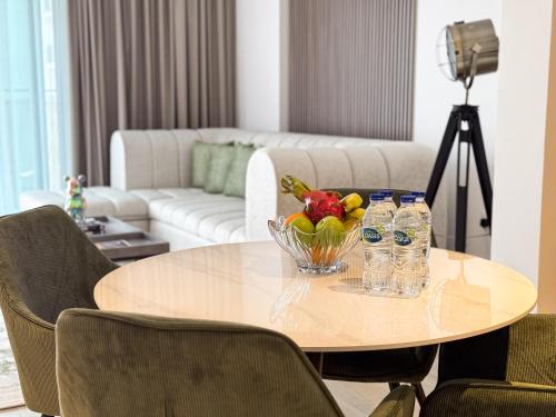 a table with a bowl of fruit and water bottles at Luxury Retreat 1BDR Apartment in Yas Island Premium Location with Pool and Gym in Yas Island