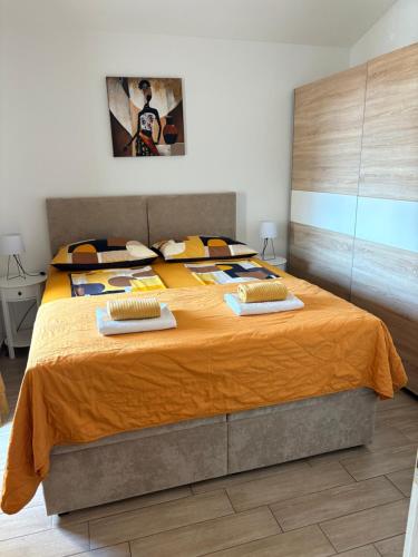 a bedroom with a large bed with orange sheets at Apartments Aurora in Zadar