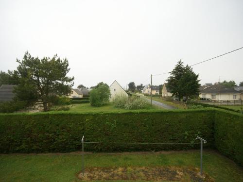 eine Hecke vor einem Hof mit einer Straße in der Unterkunft Sea View Family Escape in Denneville
