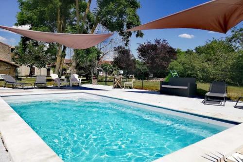 a swimming pool with an umbrella and chairs and a table at Holiday Home in Saint-Jean near Loire Castles in Frontenay-sur-Dive