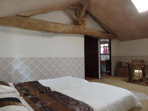 a bedroom with two beds and a wooden beam at Holiday Home in Saint-Jean near Loire Castles in Frontenay-sur-Dive