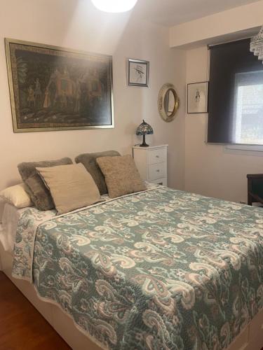 a bedroom with a bed and a painting on the wall at Primavera Congresos in Granada