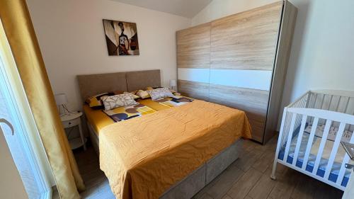 a small bedroom with a bed and a crib at Apartments Aurora in Zadar