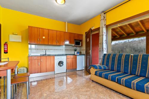 a living room with a couch and a kitchen at Apartamentos Les Cuartes in Cangas de Onís